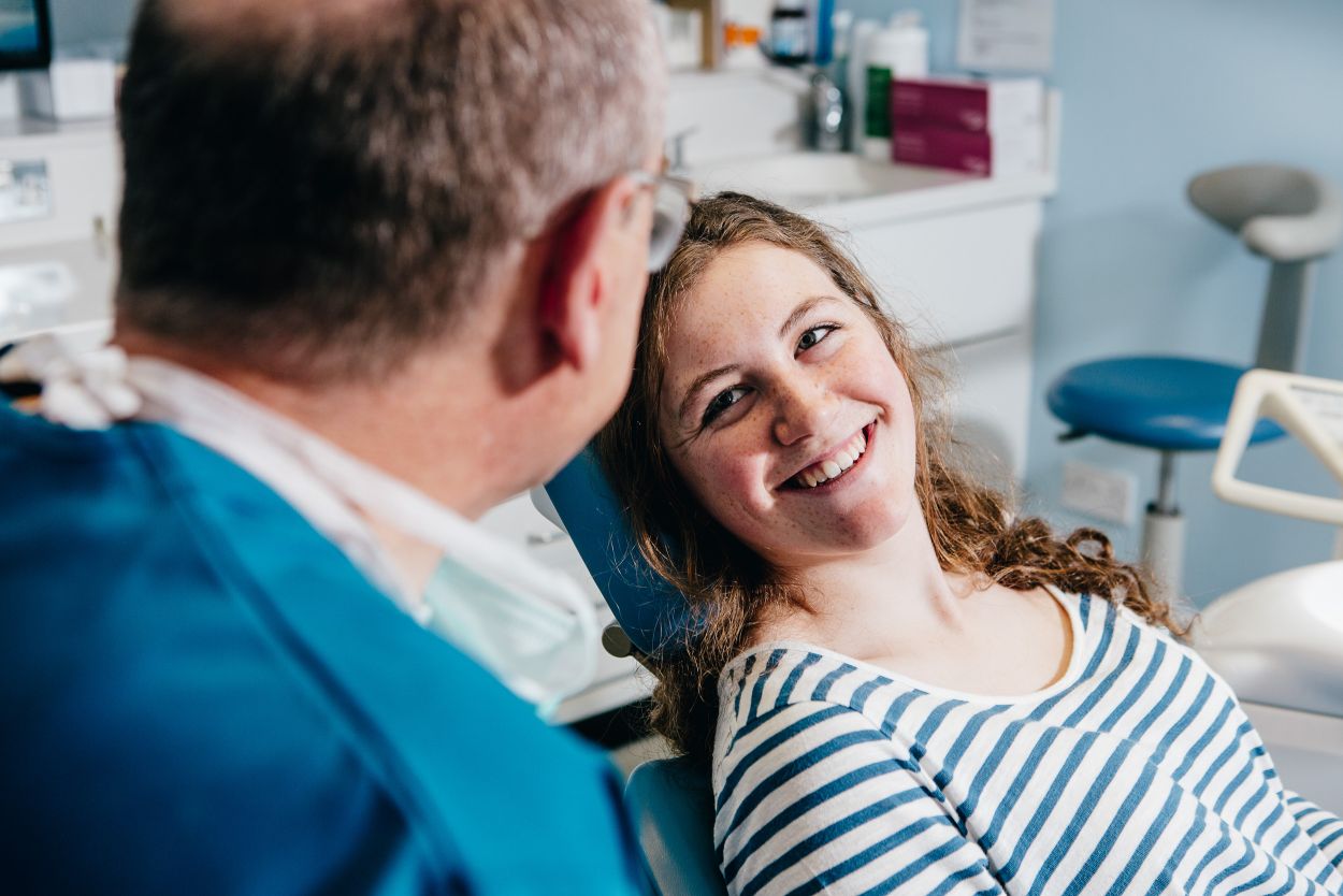 Friendly dentist chatting with a young patient during a children's dentistry appointment at Glendair Dental