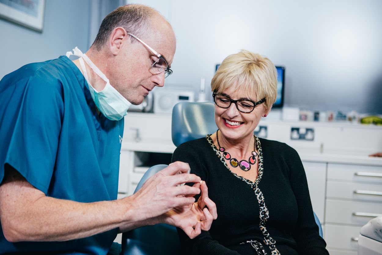 Dentist discussing dental implant treatment with a patient at Glendair Dental