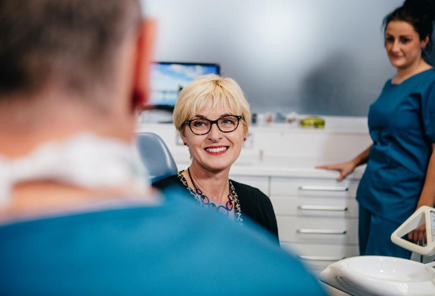 Dentist showing a patient a dental crown model at Glendair Dental